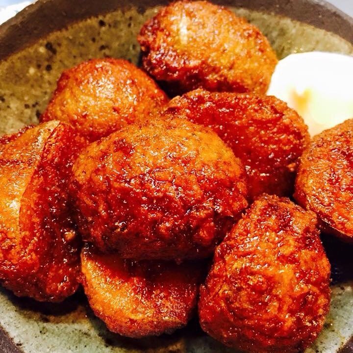 木のテーブルに焼き鳥の盛り合わせと枝豆、小皿料理が並ぶ居酒屋の卓上風景